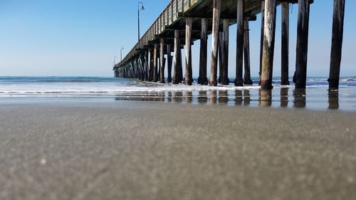 Pier on beach against sky