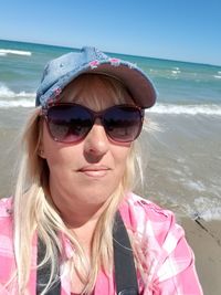 Portrait of woman wearing sunglasses on beach
