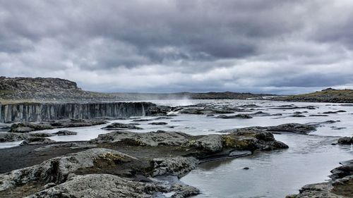 Scenic view of beach against dramatic sky