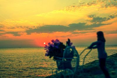 Silhouette people on beach against sky during sunset