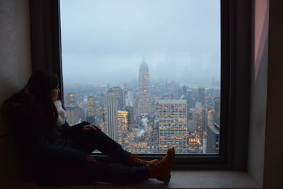 Man looking through window in city