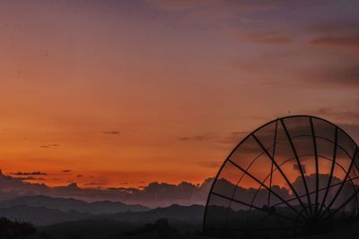 Silhouette mountain against orange sky