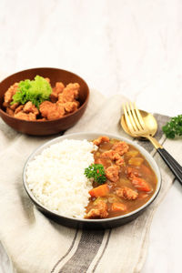 Close up chicken popcorn katsu with japanese curry, serve with white rice on ceramic plate