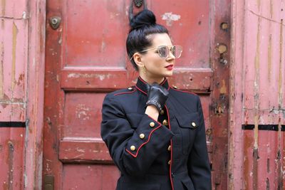 Woman wearing sunglasses against closed door