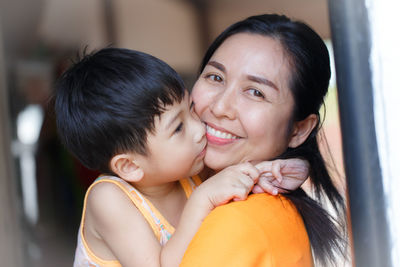 Close-up portrait of smiling woman with son
