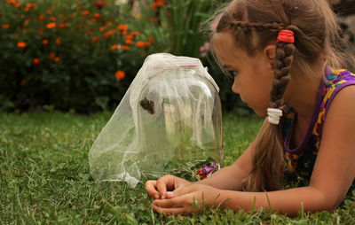 Portrait of cute girl catching insects at lawn