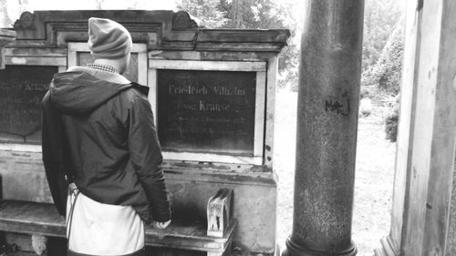 Rear view of woman standing by railing