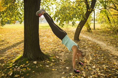 Mid adult woman exercising in park during autumn