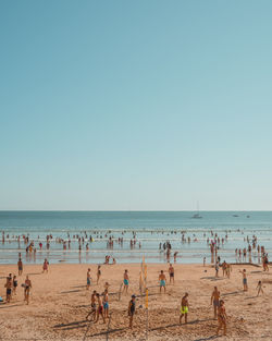 People at beach against clear sky