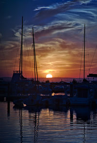 Sailboats in marina at sunset