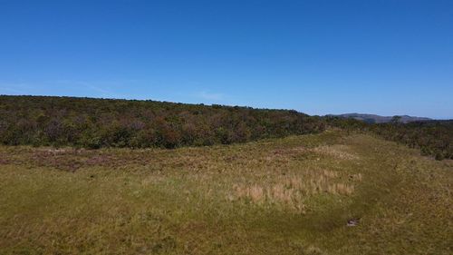 Scenic view of land against clear blue sky