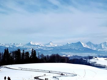 Ski lift over snowcapped mountains against sky