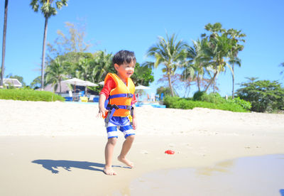 Side view of boy standing at beach