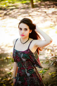 Portrait of young woman standing at park