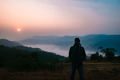 Man standing on mountain during sunset