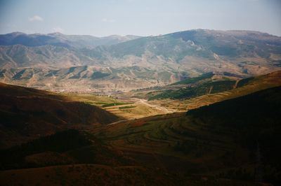 Scenic view of field and mountains against sky