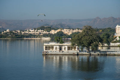 Scenic view of river by buildings against sky