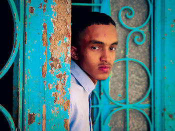 Portrait of young man on blue metal