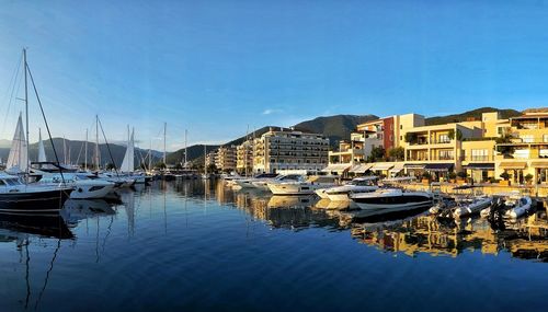 Boats moored at harbor against buildings in city