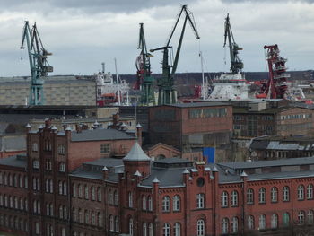 Cranes against buildings in city