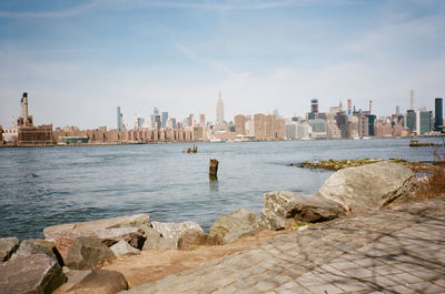 Scenic view of river by buildings against sky