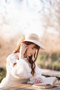 Portrait of smiling young woman sitting on field