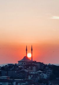 Buildings in city against sky during sunset