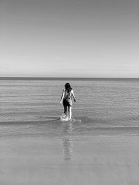 Full length of woman standing in water against sky