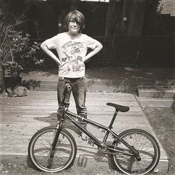 Rear view of man standing on bicycle