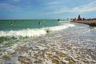 People on beach against sky