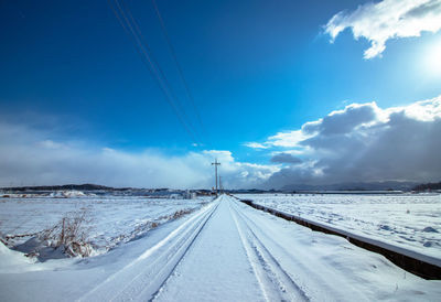 Snow covered landscape against sky