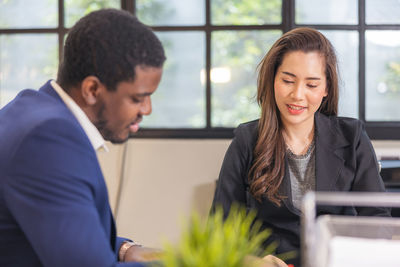 Colleagues in a boardroom discussion, seated at a table together,