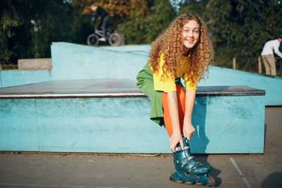 Smiling woman wearing skates at park