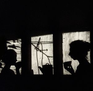 Silhouette people on window
