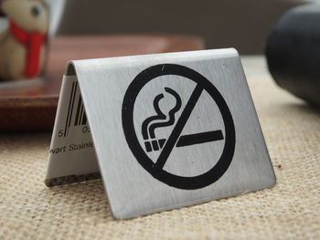 Close-up of no smoking sign on table