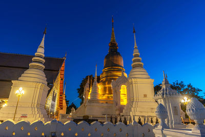 Low angle view of illuminated building against blue sky