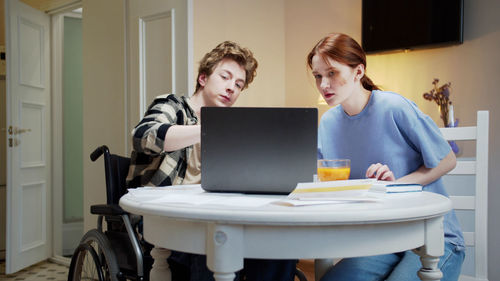Young woman and man looking at laptop
