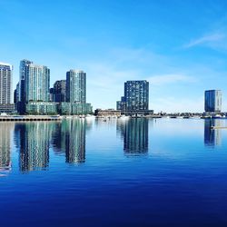Sea and modern buildings in city against sky