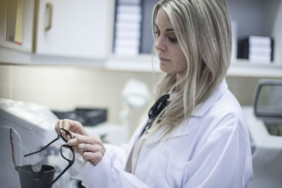 Optician looking at glasses frame