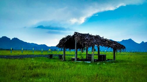 Scenic view of grassy field against cloudy sky