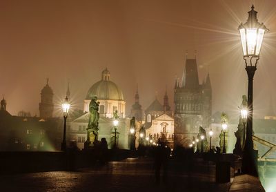 Illuminated charles bridge and buildings in city at night