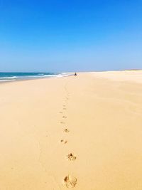 Scenic view of beach against clear blue sky