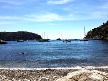 Sailboats in sea against sky