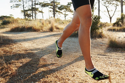 Low section of man walking on road