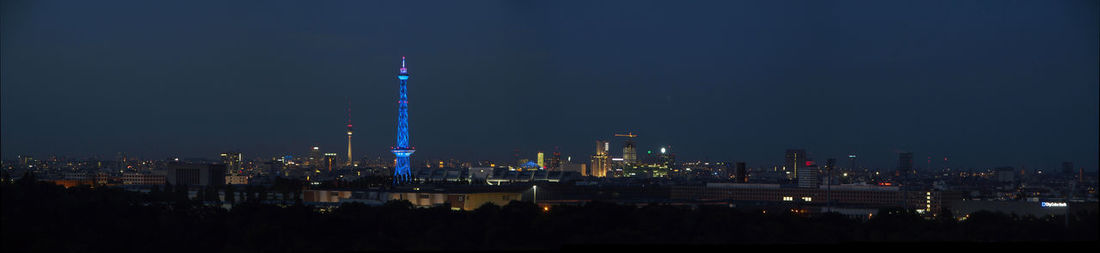 Illuminated buildings in city against sky at night