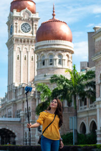 Full length of young woman standing outside building