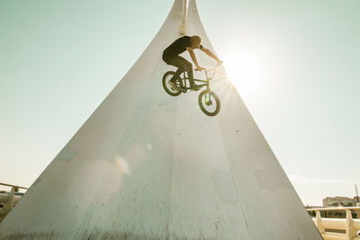 Low angle view of man riding bicycle against sky