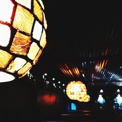 Low angle view of illuminated lights against sky at night