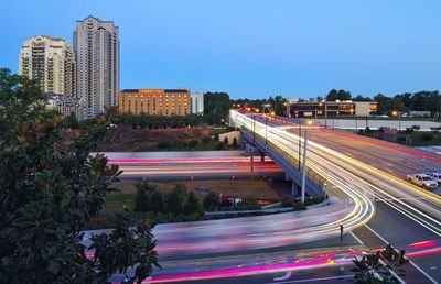 Light trails on road along buildings