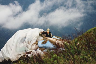 Rear view of woman on mountain against sky